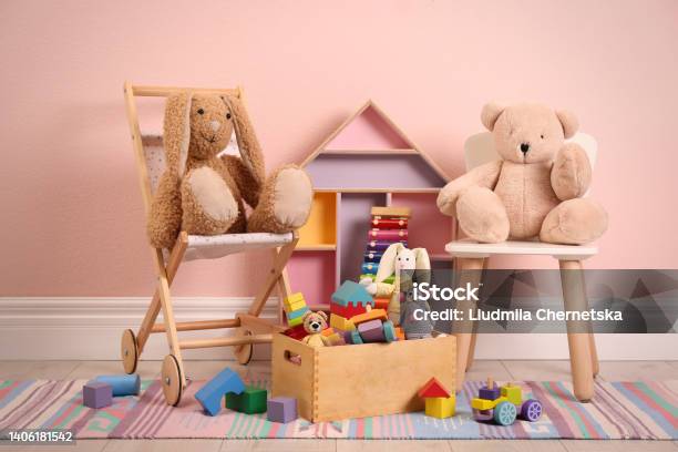 Set Of Different Cute Toys On Floor Near Pink Wall Stock Photo - Download Image Now - Dollhouse, Baby Stroller, Bear