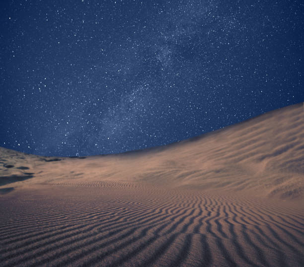 istock Scenic view of sandy desert under starry sky in night 1406183412