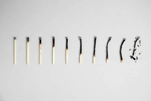 Photo of Different stages of burnt matches on light background, flat lay