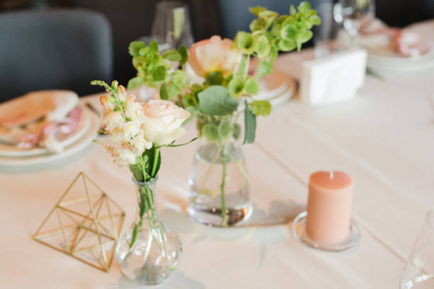 istock Table setting at the wedding reception. Floral compositions with beautiful flowers and greenery, candles, laying and plates on a decorated table. 1406183810