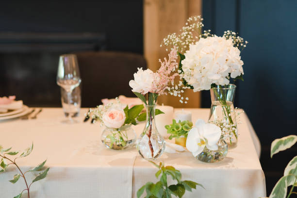 istock Table setting at the wedding reception. Floral compositions with beautiful flowers and greenery, candles, laying and plates on a decorated table. 1406183835