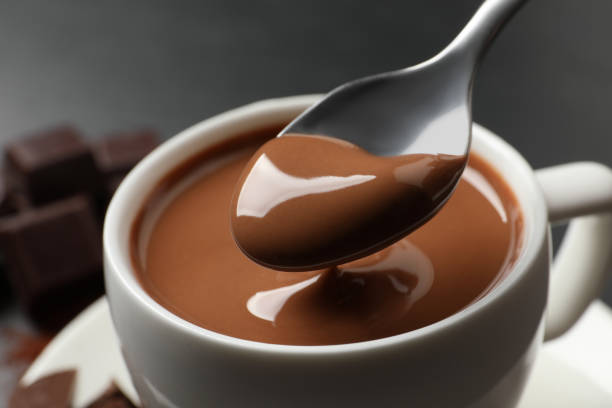 istock Spoon with yummy hot chocolate over cup, closeup 1406183972