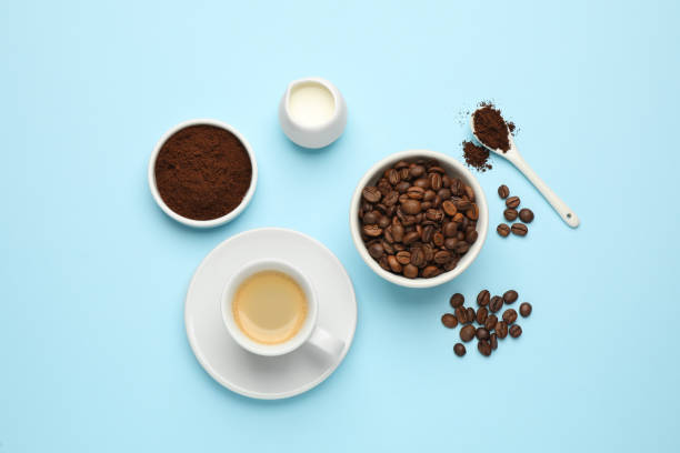 istock Flat lay composition with ground coffee and roasted beans on light blue background 1406184683