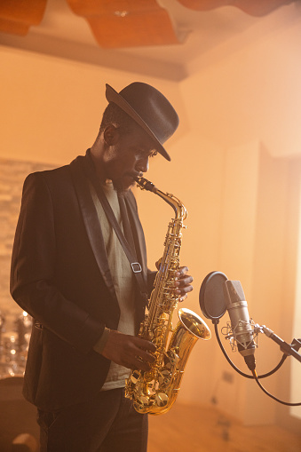 Male African Jazz Musician Playing Saxophone In A Recording Studio
