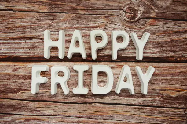 Happy Friday text message on wooden background