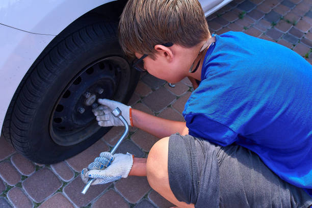 istock Father And Son Changing Car Wheel 1406185537