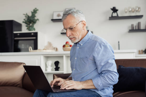 istock Mature aged man working on laptop at home 1406185833