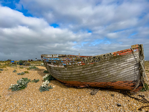 Views of the shingle beach and abandoned fishing boats of Dungeness, with the nuclear power station in the background