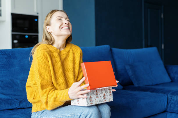 Overjoyed woman unpack box with her birthday present