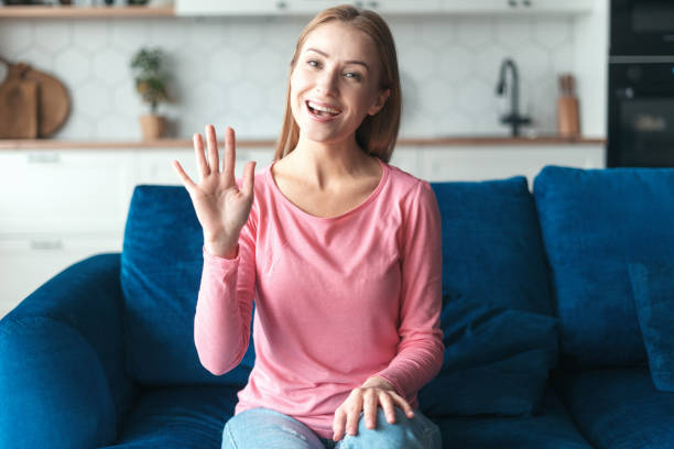 istock Happy woman looking at camera, waving hello 1406187399