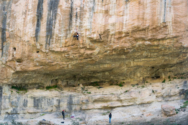 grimpeur escaladant un mur dans la zone d’escalade de chulilla, valence - rescue mountain horizontal three people photos et images de collection