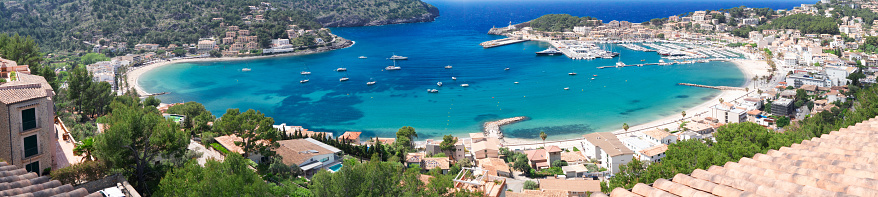 view of Port Soller harbour with house roofs, Mallorca at summer, wide panorama, web banner