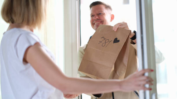 istock Woman receives parcel from courier with heart on doorstep 1406191055