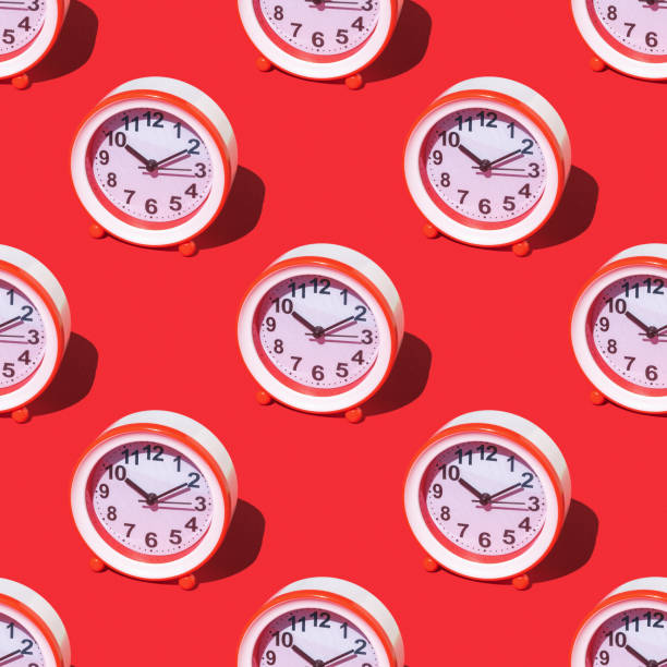 istock Seamless pattern of red and white alarm clocks on a red background. 1406191367