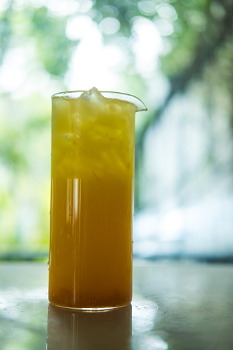 Single glass of orange juice with ice