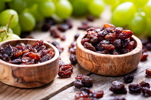 Prunes on small plate with jam from the plums on a wooden table. Dried Plums. Healthy and vegetarian food.