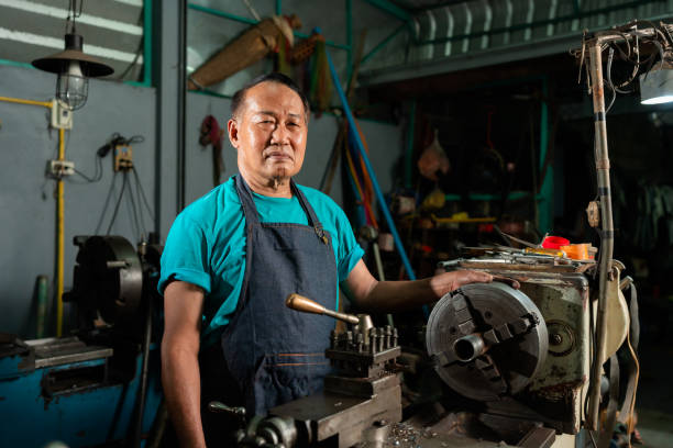 istock A senior Asian craftsman, standing closely and carefully controlling a lathe, inside a small factory of his family business.. 1406199631