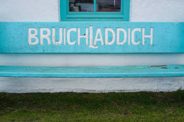 деревянная скамейка перед заводом по производству виски bruichladdich на острове айлей - bruichladdich whisky стоковые фото и изображения