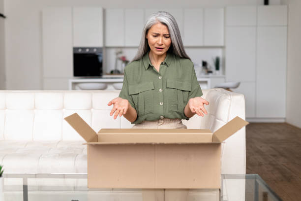 istock Disappointed middle-aged Asian lady upset with an online purchase 1406202556