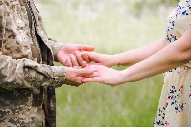 istock gentle female hands and a man in a military uniform 1406202588