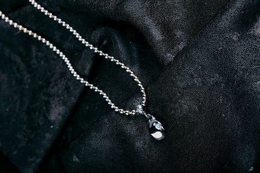 Golden necklace with Aquamarine gemstone isolated on grey.