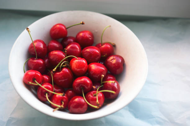 Bowl white with bunch of cherries  Bowl white with bunch of cherries