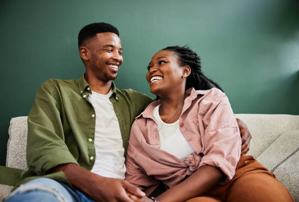 istock Young couple laughing together on their sofa at home 1406208035