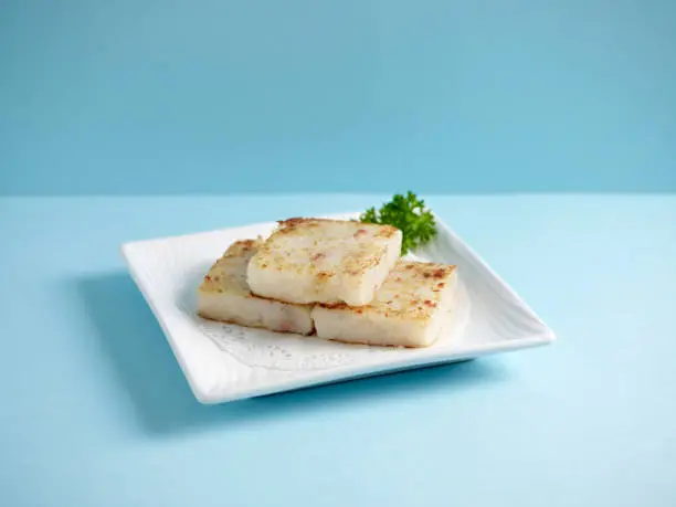 Photo of Pan Fried Radish Cake with sweet soy sauce served in a dish isolated on mat side view on grey background