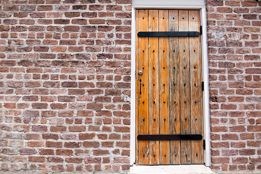 An old vintage wooden door from a brick building.