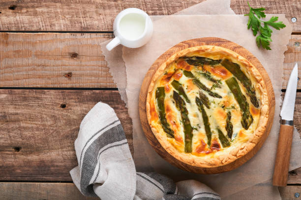 istock Quiche. Homemade asparagus pie or quiche with cheese and spinach on old wooden table background. Asparagus and cheese tart. French Quiche. Top view. 1406211322