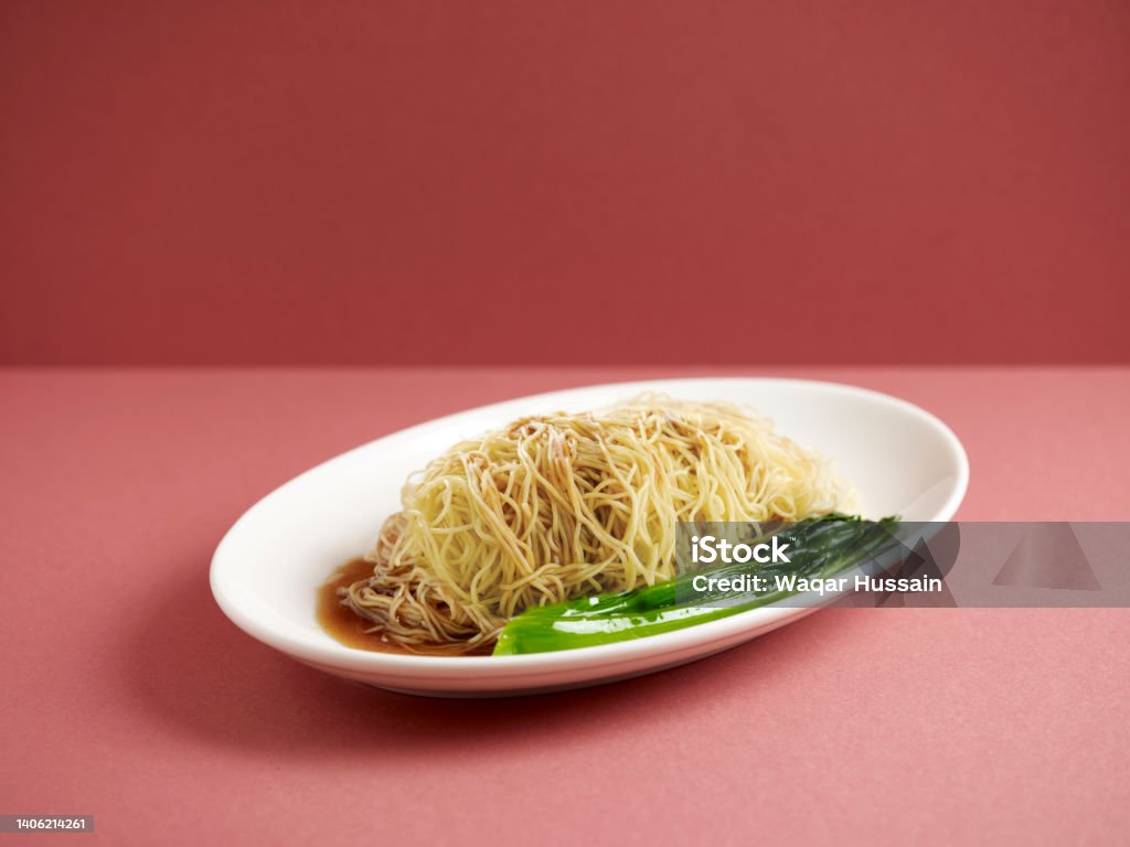 Plain Noodle with chopsticks served in a dish isolated on mat side view on grey background Bowl Stock Photo