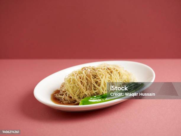 Plain Noodle With Chopsticks Served In A Dish Isolated On Mat Side View On Grey Background Stock Photo - Download Image Now