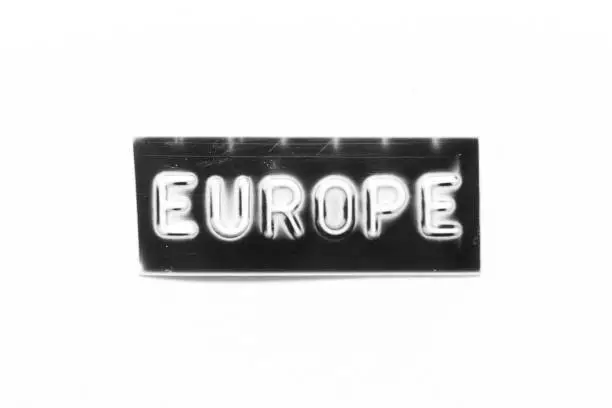 Photo of Black color banner that have embossed letter with word europe on white paper background