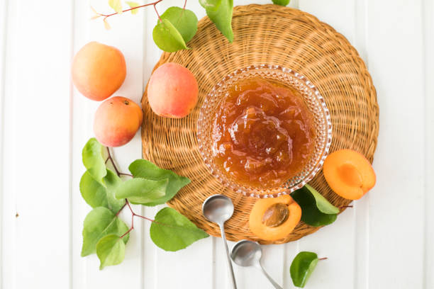 istock Jam from Apricots and  Fresh Apricots Wooden Background 1406214531