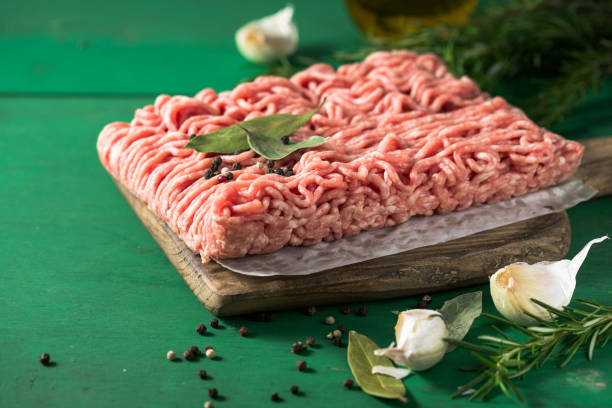 istock Raw Mince, minced Ground beef meat on a cutting board. Green background. Top view 1406215402