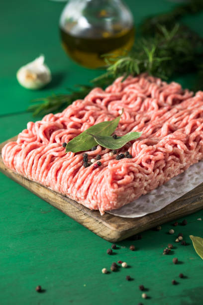 istock Raw Mince, minced Ground beef meat on a cutting board. Green background. Top view 1406215405
