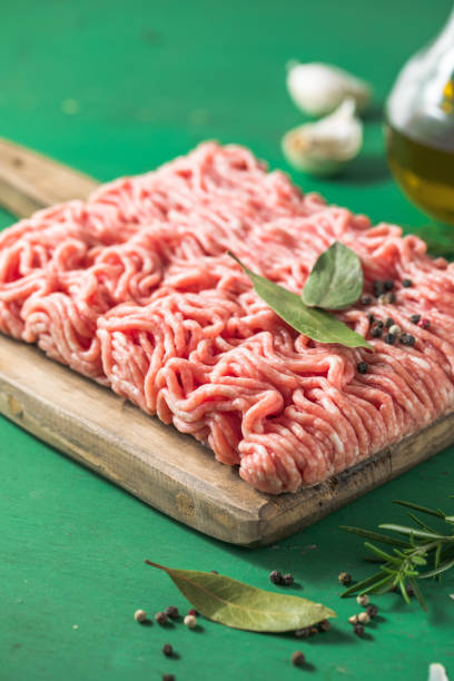 istock Raw Mince, minced Ground beef meat on a cutting board. Green background. Top view 1406215409
