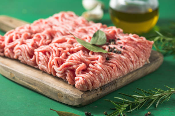 istock Raw Mince, minced Ground beef meat on a cutting board. Green background. Top view 1406215414