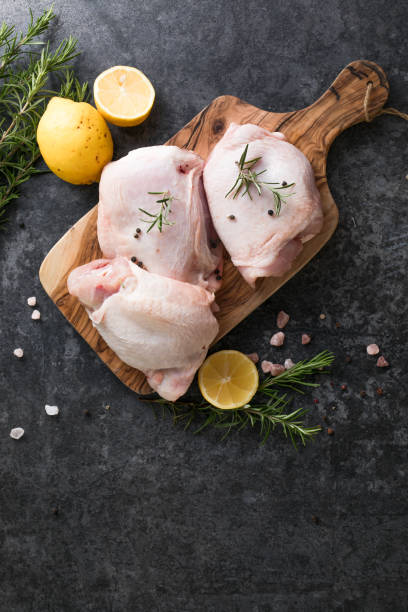 istock Chicken thighs with , lemon, fresh rosemary,. Copy space. 1406215701