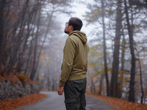 istock Young handsome man posing in autumn forest. 1406218276