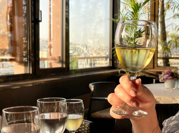 istock Glass of white wine in a person's hand 1406219371