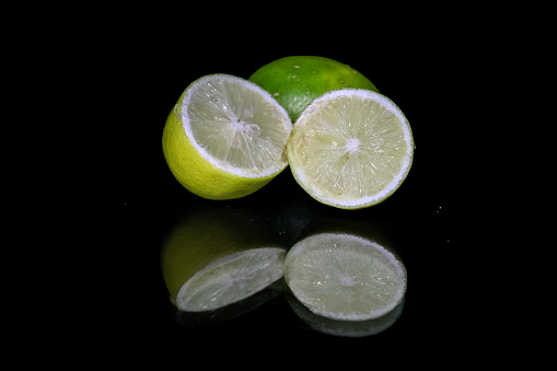 Yellow lemon slices isolated on black background macro close up reflection