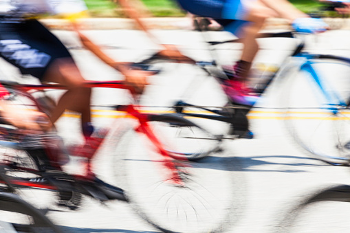 Intentional camera movement shot of riders and spinning wheels on bikes in a local bike race.