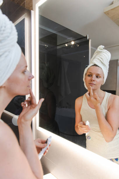 istock Woman Applying Moisturizing Face Cream 1406221112