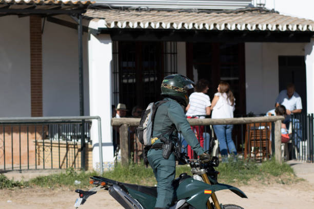 Person with yellow crash helmet on motorcycle with yellow gate in background
