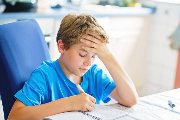 istock Young boy doing his homework at home. School kid learning. 1406228084