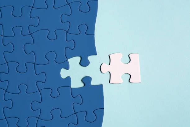 istock Dark blue jigsaw puzzle with some missing pieces on blue background. Flat lay. 1406229172