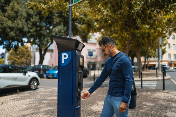 Man pays for parking with coin in a special pay machine in Lisbon, Portugal Pay, Coin, Parking, Lisbon, Europe parking meter stock pictures, royalty-free photos & images