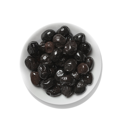 black olives in a white bowl, view from above, isolated