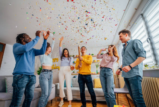 istock Friends throwing confetti during party at home 1406232195
